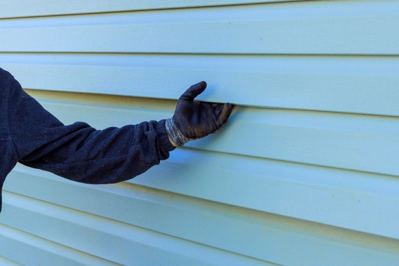 Professional Siding Installer at Work